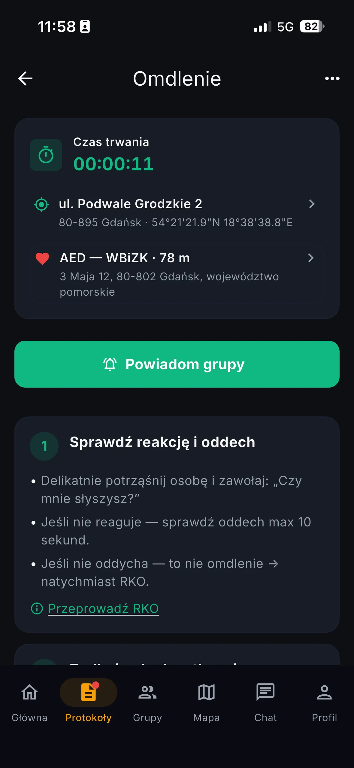 Protokół Omdlenie z licznikiem czasu trwania, adresem zdarzenia, najbliższym AED w odległości 78 m, przyciskiem Powiadom grupy i pierwszym krokiem Sprawdź reakcję i oddech.